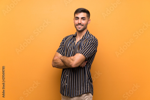 Handsome man with beard over isolated background with arms crossed and looking forward