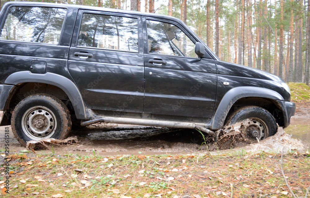 black jeep SUV driving on abandoned sand road in forest black jeep SUV driving on abandoned sand road in forest