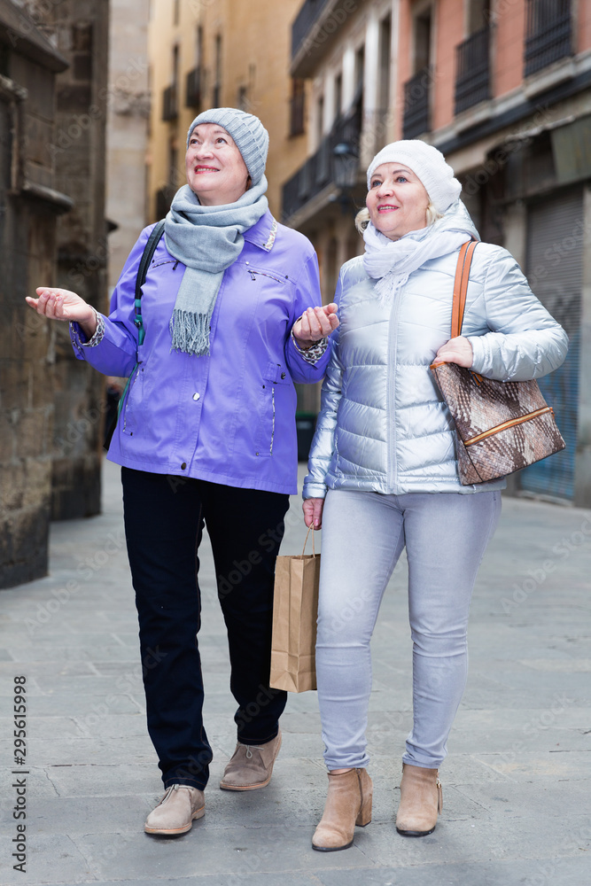 Senior females walking along city streets