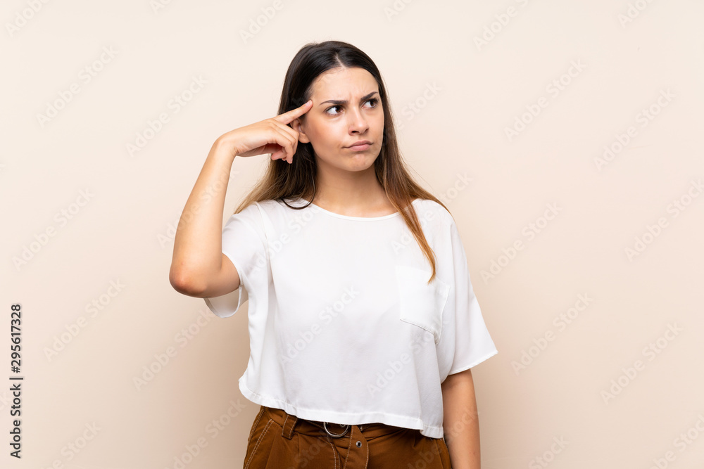 Young brunette woman over isolated background making the gesture of madness putting finger on the head Young brunette woman over isolated background making the gesture of madness putting finger on the head