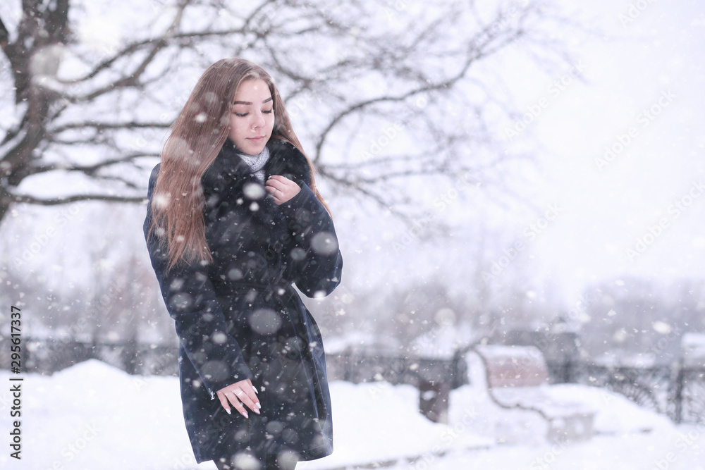 Girl in a winter park in snowfall