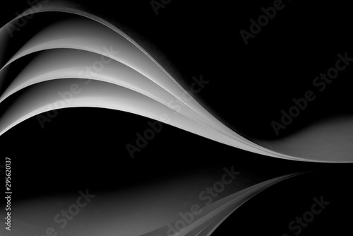 curved white sheets of paper against a dark background
