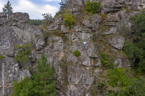 climber on a safety rope climbs a cliff aerial view