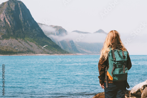 Woman tourist walking alone enjoying sea view outdoor travel vacations lifestyle girl with backpack in Norway