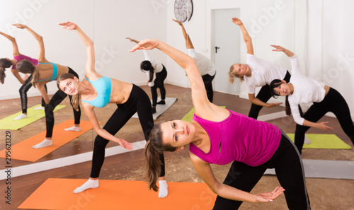 Flexible girls practice yoga in in fitness center