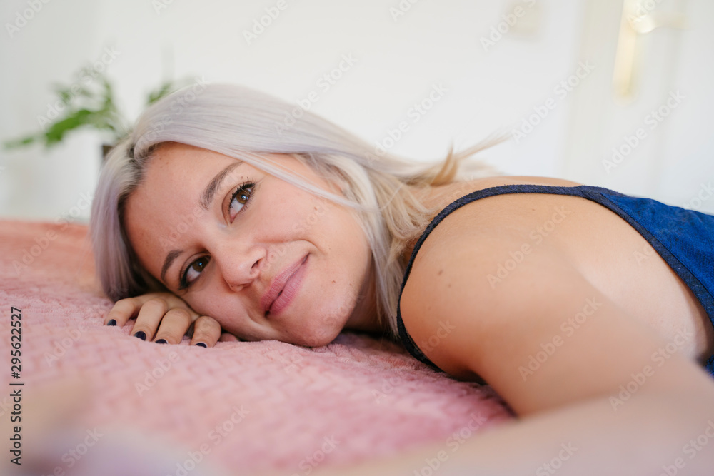 Fototapeta premium The importance of a good night sleep. Calm and relax dreams. Beauty and healthy lifestyle. Single woman resting on a pillow at home. Lifestyle at home. Young people. White clean mindfulness room.