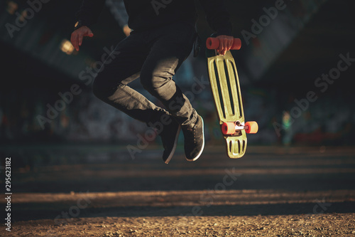 Fotografia Jumping man holds skateboard