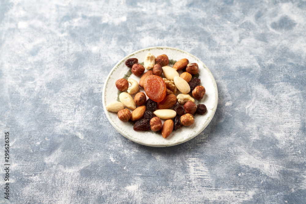 Nuts, raisins and apricots on rustic wooden background. Concept for healthy snack. Copy space. Nuts, raisins and apricots on rustic wooden background. Concept for healthy snack. Copy space.