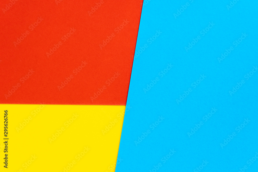 Fototapeta premium Yelllow blue red color paper background. Geometric figures, shapes. Abstract geometric flat composition. Empty space on monochrome cardboard