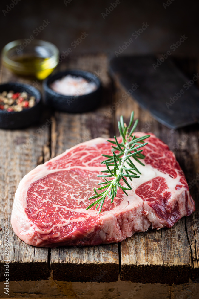 Raw fresh meat Ribeye Steak and seasonings on wooden background, rustic style Raw fresh meat Ribeye Steak and seasonings on wooden background, rustic style