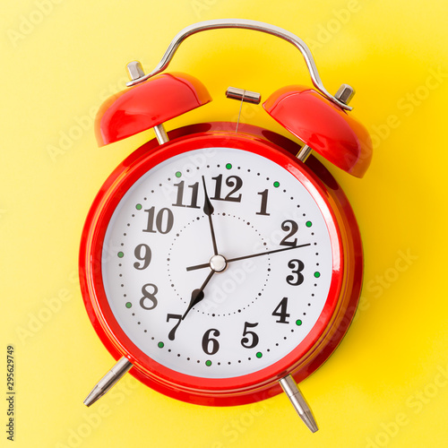 Red alarm clock on yellow background, wake up