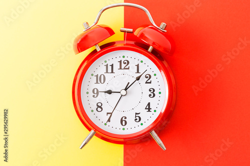 Alarm clock on the red and yellow background