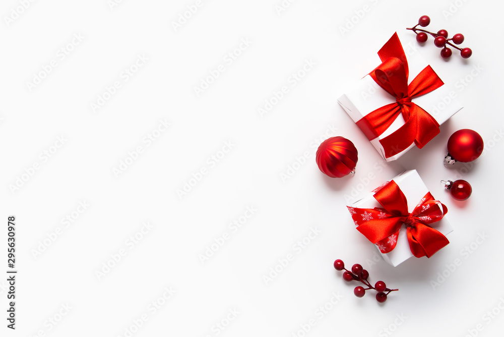 Christmas and New Year holiday background. Xmas greeting card. Christmas red ribbon gifts and ornaments on white background top view. Flat lay Christmas and New Year holiday background. Xmas greeting card. Christmas red ribbon gifts and ornaments on white background top view. Flat lay