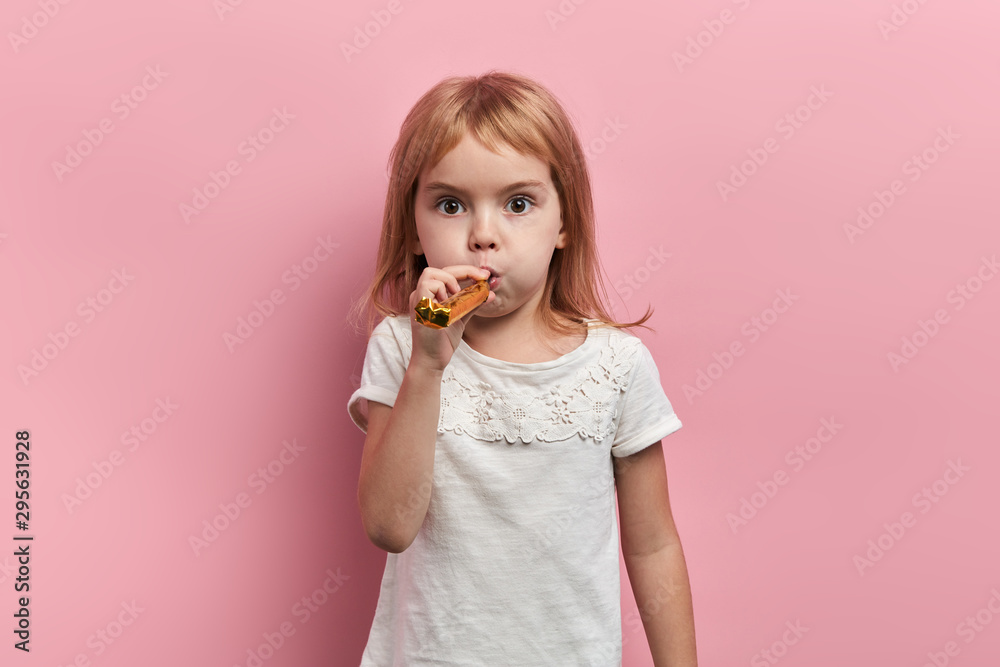 funny pleasant little kid using blowing horn, celebrating birthday, having a party, close up portrait, isolated pink background, studio shot, childhood funny pleasant little kid using blowing horn, celebrating birthday, having a party, close up portrait, isolated pink background, studio shot, childhood