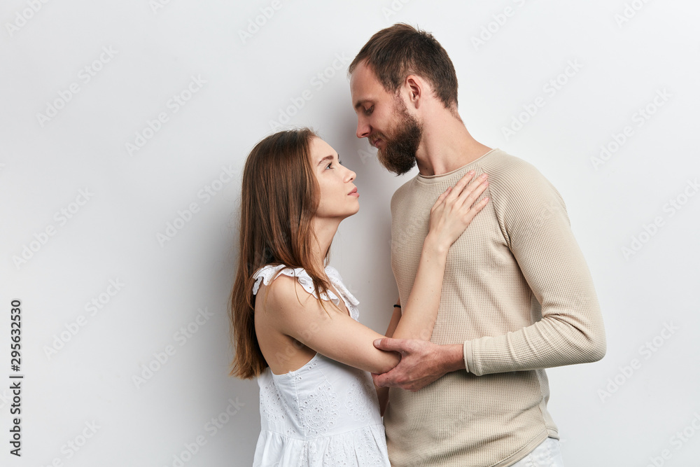 beautiful woman and man looking at each other with tender expression, close up side view photo. isolated white background