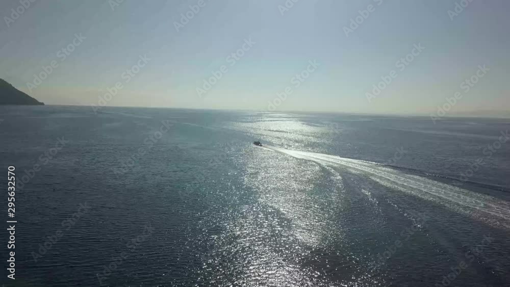 wonderful extreme wide shot of the ocean, a vessel moving across towards an island. wonderful extreme wide shot of the ocean, a vessel moving across towards an island.