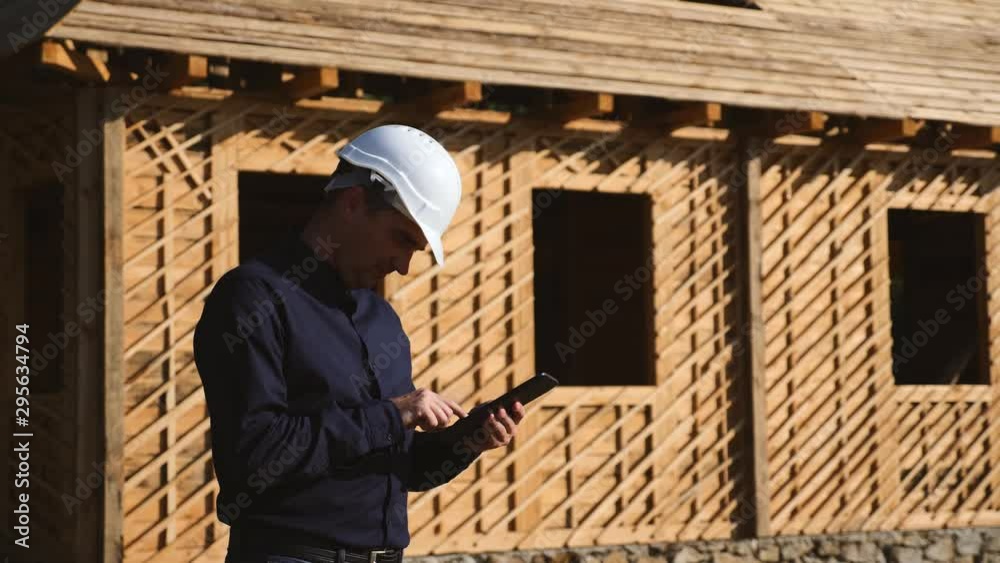 two engineers in a white helmet are considering a project to build a house made of natural materials. Teamwork. two engineers in a white helmet are considering a project to build a house made of natural materials. Teamwork.