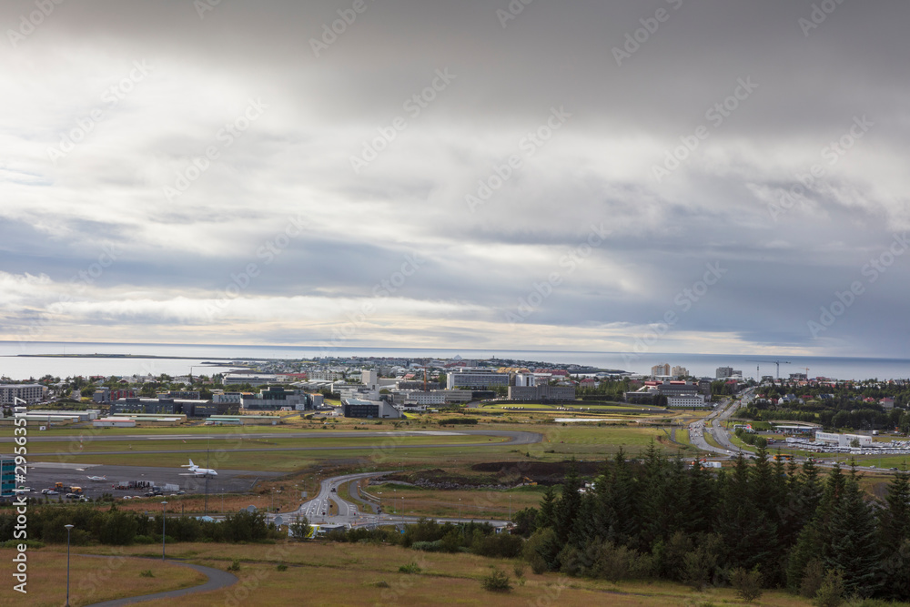 A cityscape of Reykjavík, the capital and largest city of Iceland, photographed from a hill on a cloudy summer day.