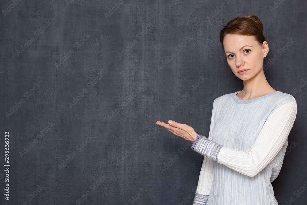 Portrait of serious focused woman pointing with hand at left Portrait of serious focused woman pointing with hand at left