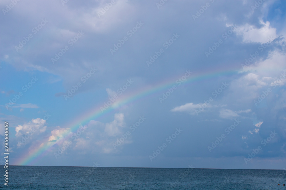 Black calm sea in Sochi and a rainbow in the morning