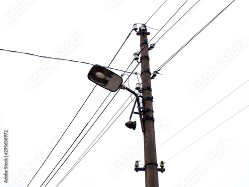 A power line, street lamp and white sky.