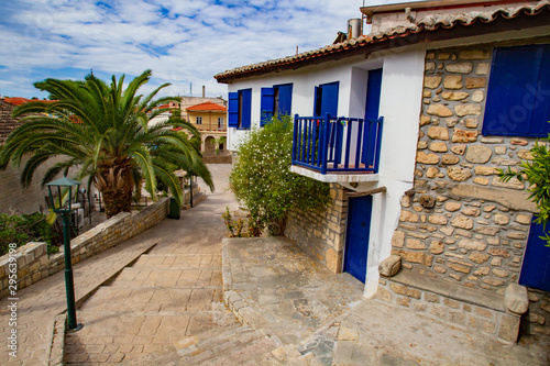 Greece. Street of the resort. A picturesque house with blue shutters. Rest in a small town. Pastoral landscape. Summer trip to Greece. Mediterranean.