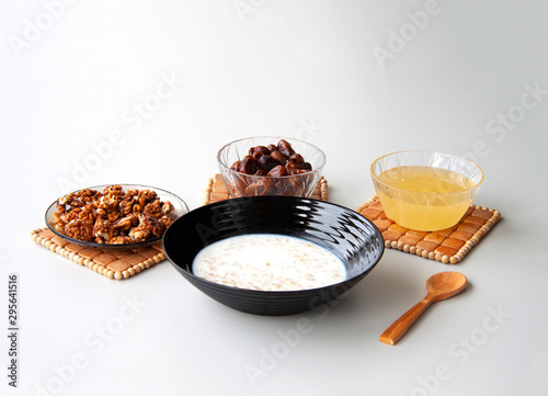 Healthy breakfast with milk porridge, walnuts, dates and honey