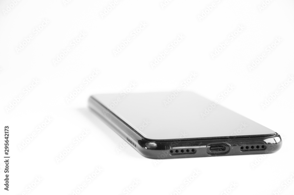 Black smartphone lies on a table on a white background. Black smartphone lies on a table on a white background.