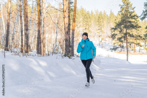 Winter cross-country exercise. Runner runs in the snow. Young female fitness model doing sports in the cold season, hardening. the concept of health