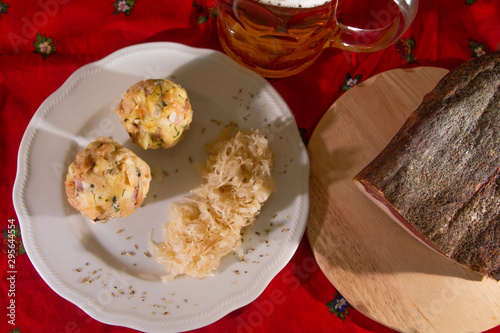 two knodels on the plate with sauerkraut and speck on the background and mug of beer and Christmas tablecloth