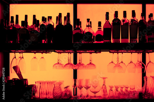 Bottles and glasses sitting on shelf in a bar, trade marks removed