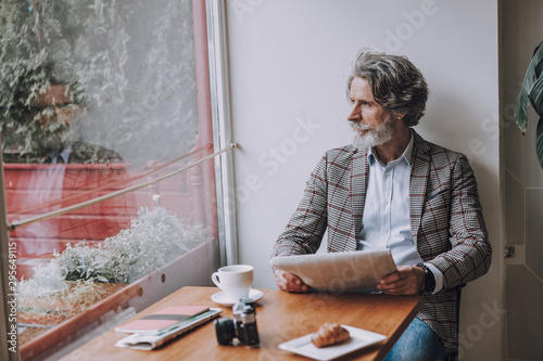 Foto Mature man in cafe with newspaper and coffee stock photo