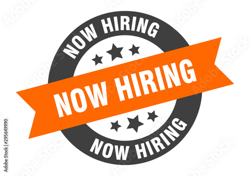 now hiring sign. now hiring orange-black round ribbon sticker
