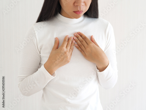 gastroesophageal reflux disease or GERD breathing difficulty in asian woman. She use hand touching chest on isolated white background use for health care concept. photo