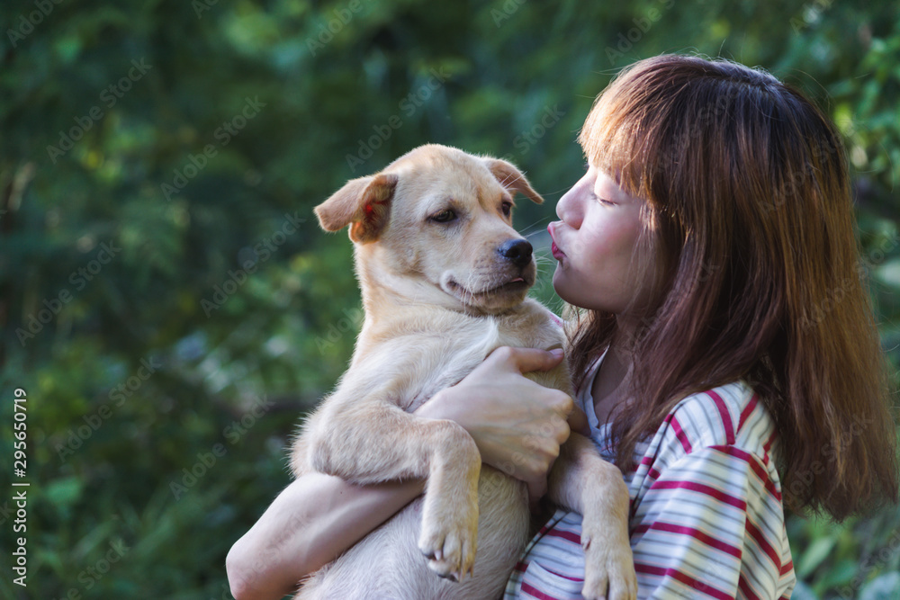 Portrait girl hug with her puppy on nature background. Portrait girl hug with her puppy on nature background.