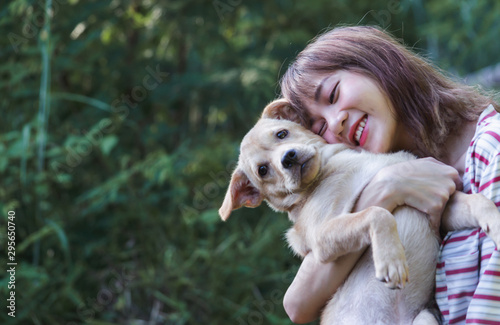 Portrait girl hug with her puppy on nature background.