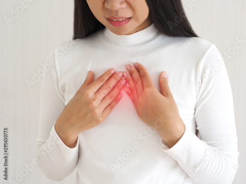 gastroesophageal reflux disease or GERD breathing difficulty in asian woman. She use hand touching chest on isolated white background use for health care concept.