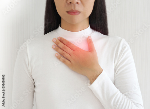 gastroesophageal reflux disease or GERD breathing difficulty in asian woman. She use hand touching chest on isolated white background use for health care concept.