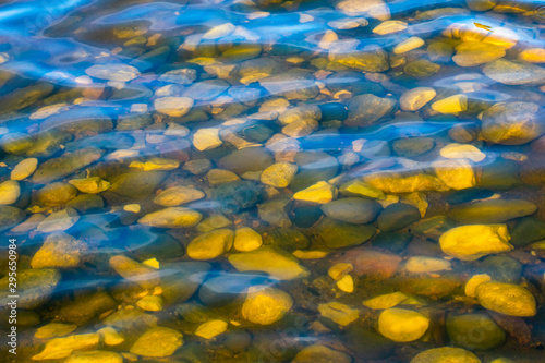Insanely beautiful view of the rounded cobblestones in the clear water. © Ilia Petukhov