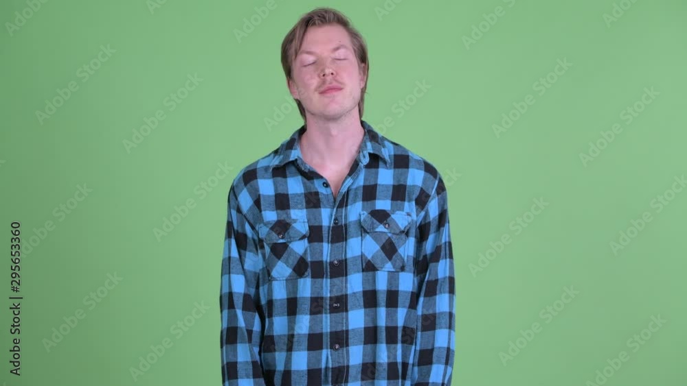Happy young handsome hipster man relaxing with eyes closed