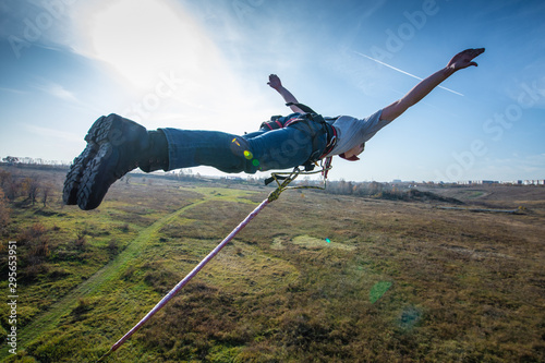 Obraz na plátně man bungee jumping on green meadow background