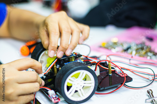 High school student is training to assemble robots for learning.