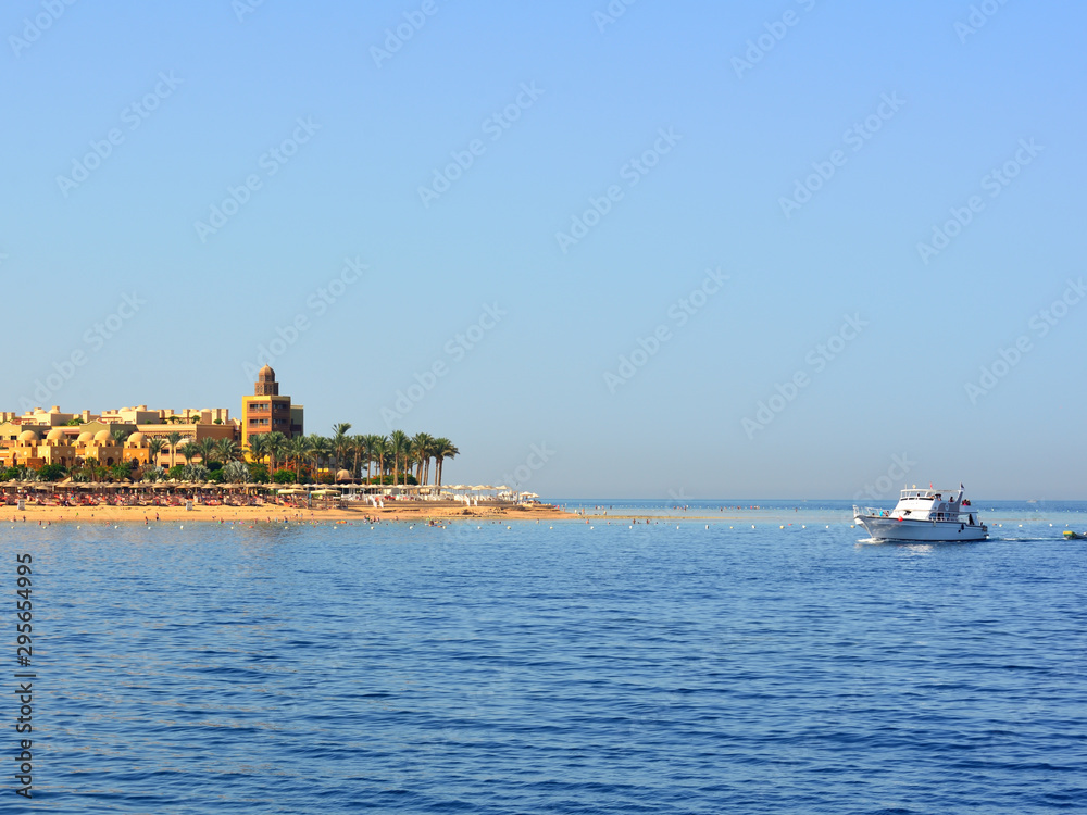 Egyptian red sea beach with palms and yacht