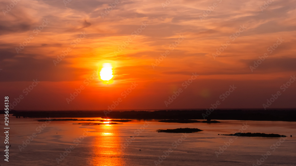 Dramatic colorful golden susnet with moving clouds on the Volga river. Evening time, warm illumination. Calm, peaceful, atmospheric view, relaxation concept Dramatic colorful golden susnet with moving clouds on the Volga river. Evening time, warm illumination. Calm, peaceful, atmospheric view, relaxation concept