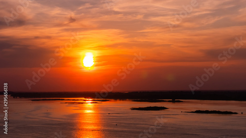 Dramatic colorful golden susnet with moving clouds on the Volga river. Evening time  warm illumination. Calm  peaceful  atmospheric view  relaxation concept