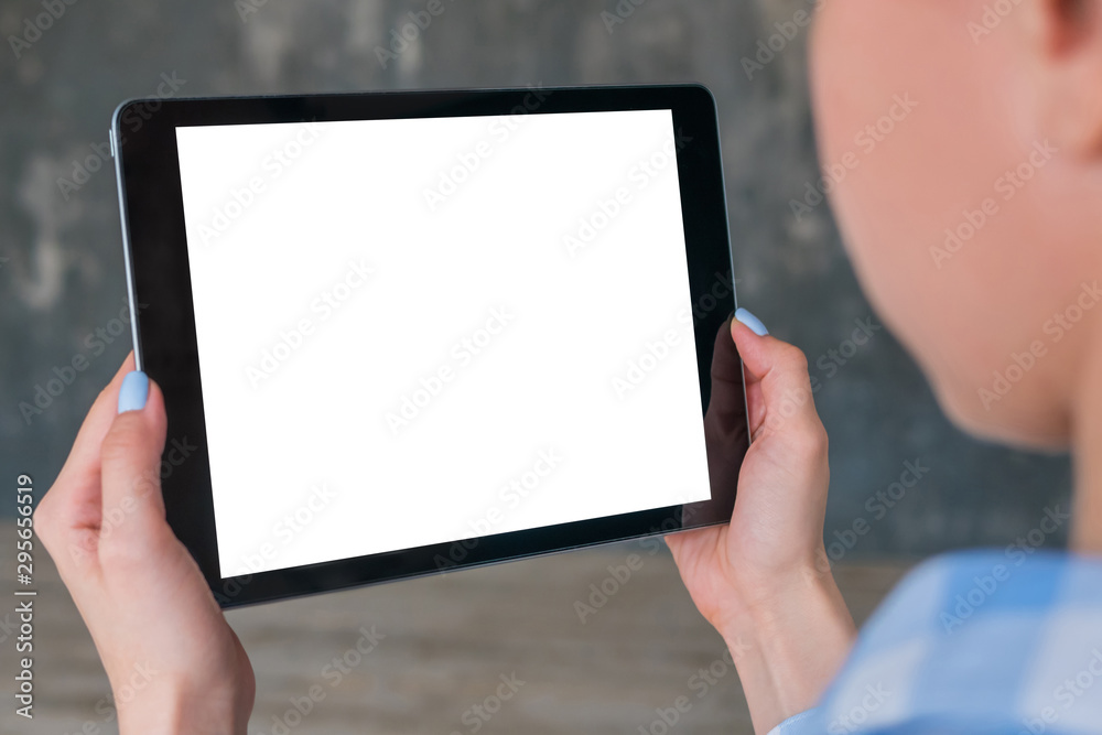 Mockup image: over shoulder close up view of woman looking at modern digital tablet computer device with white blank screen. Mock up, copyspace, leisure time, template and technology concept