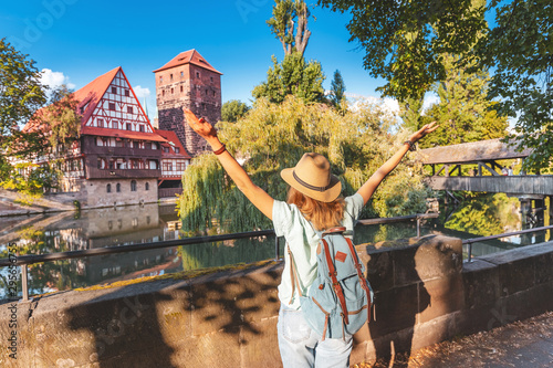 Slika na platnu Happy asian woman tourist enjoying sunset view of the old town of Nurnberg city and Pegnitz river