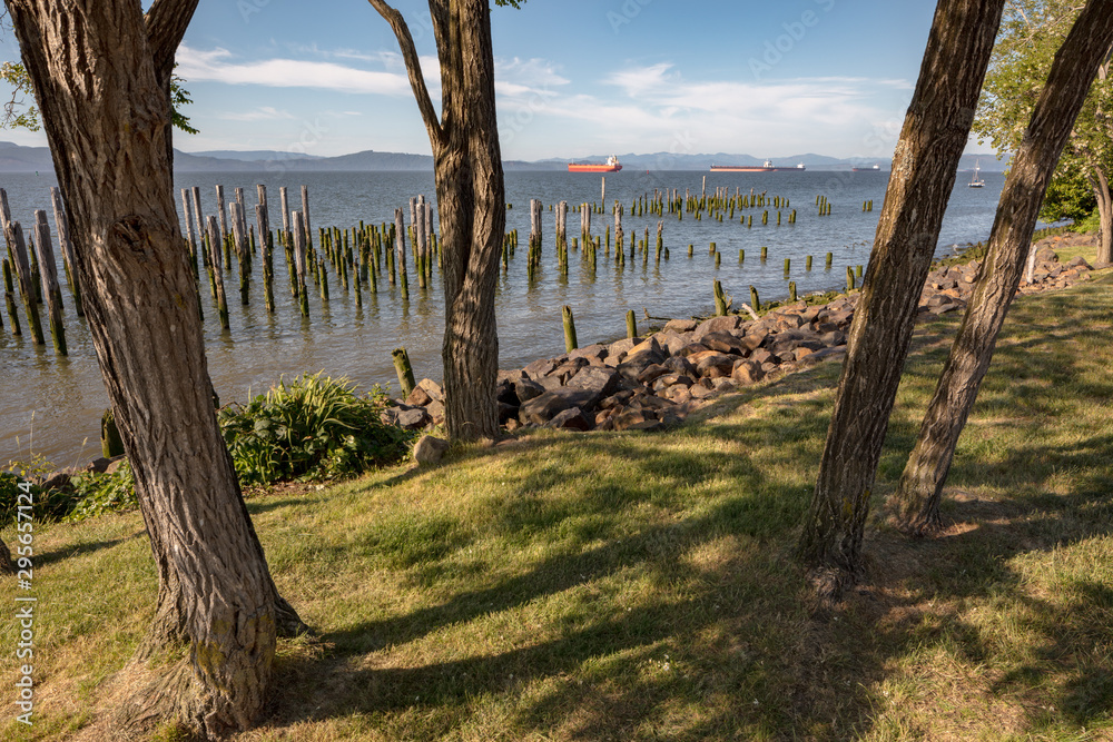 View of Columbia River from City of Astoria Maritime Museum, Oregon, USA. Waterfront river view with wooden pylons, boats in distance. View of Columbia River from City of Astoria Maritime Museum, Oregon, USA. Waterfront river view with wooden pylons, boats in distance.