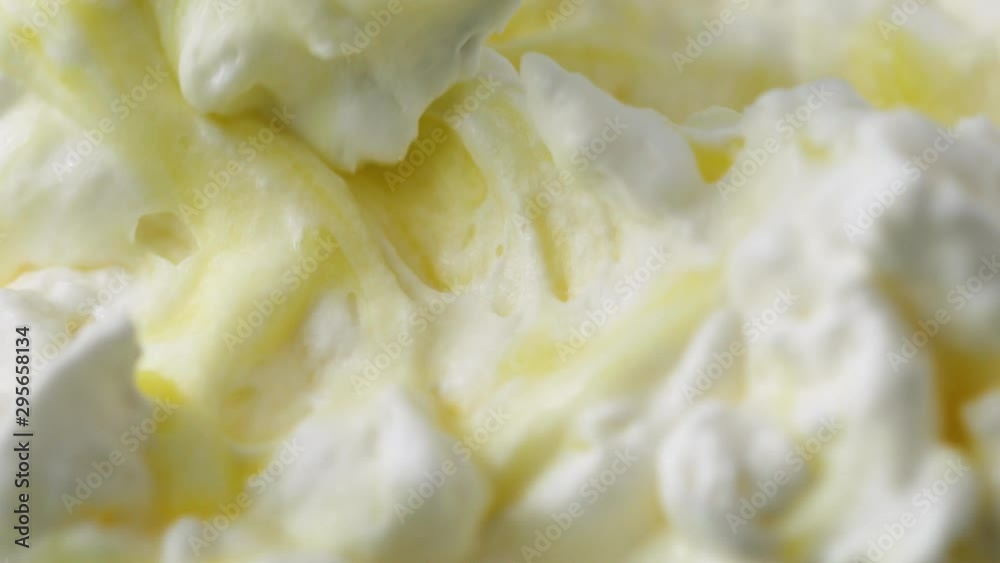 Close video of stirring whipped cream into lemon pudding with a spoon. Close video of stirring whipped cream into lemon pudding with a spoon.