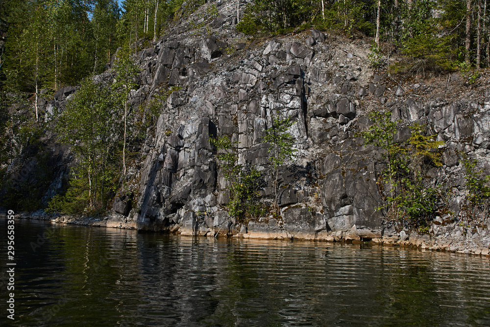 Water landscape of a mountain park.The picturesque landscape of the mountain natural park Ruskeala. Visible are rocks, a lake, coniferous forest, mountains, wildlife. Russia, Karelia. Water landscape of a mountain park.The picturesque landscape of the mountain natural park Ruskeala. Visible are rocks, a lake, coniferous forest, mountains, wildlife. Russia, Karelia.